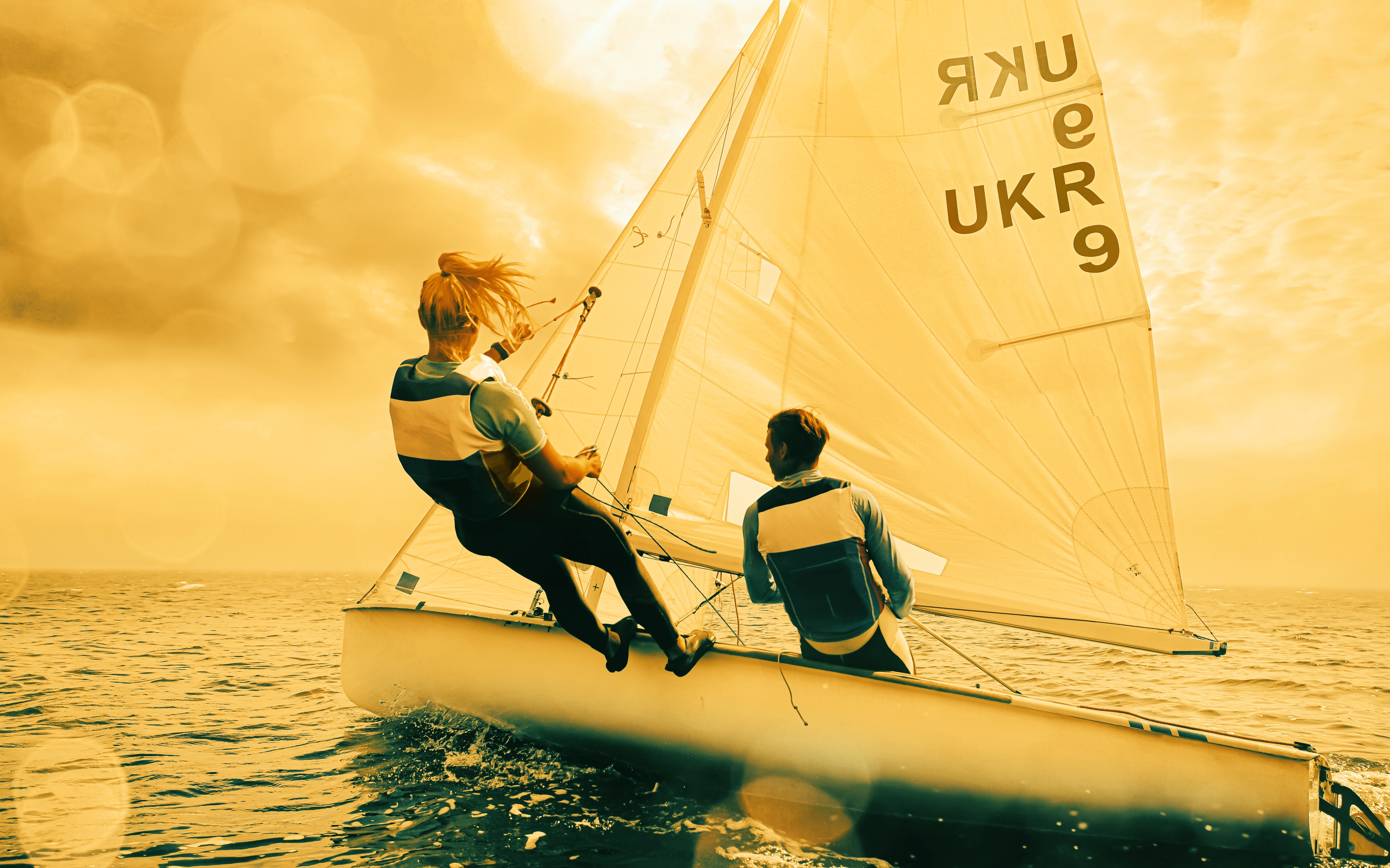 Two people on a sailing boat, working together
