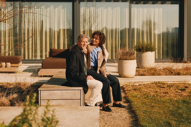 Man en vrouw zitten voor een huis